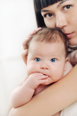caring mother kissing her little cute baby girl